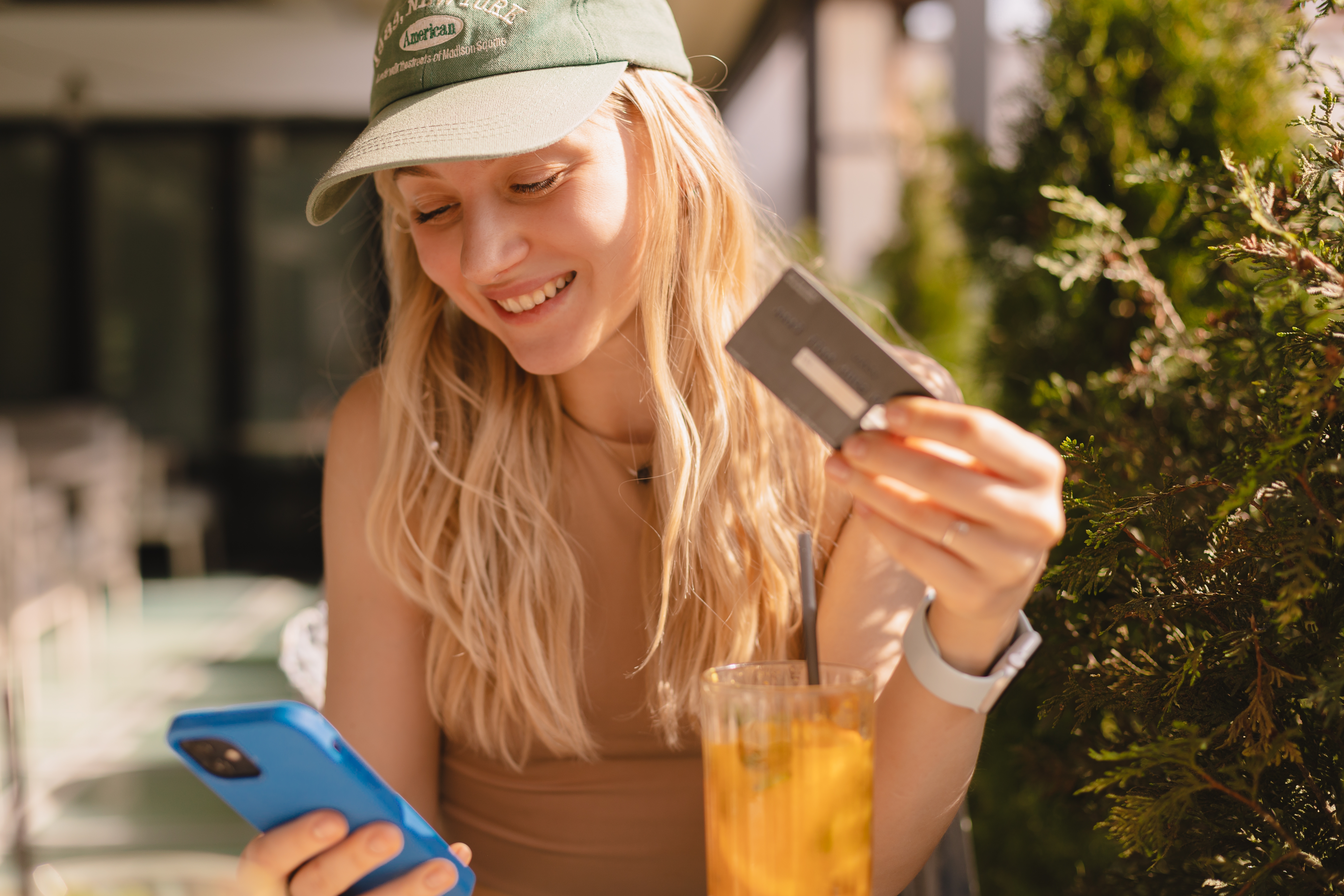 Happy,young,blonde,woman,with,cap,customer,shopper,holding,credit