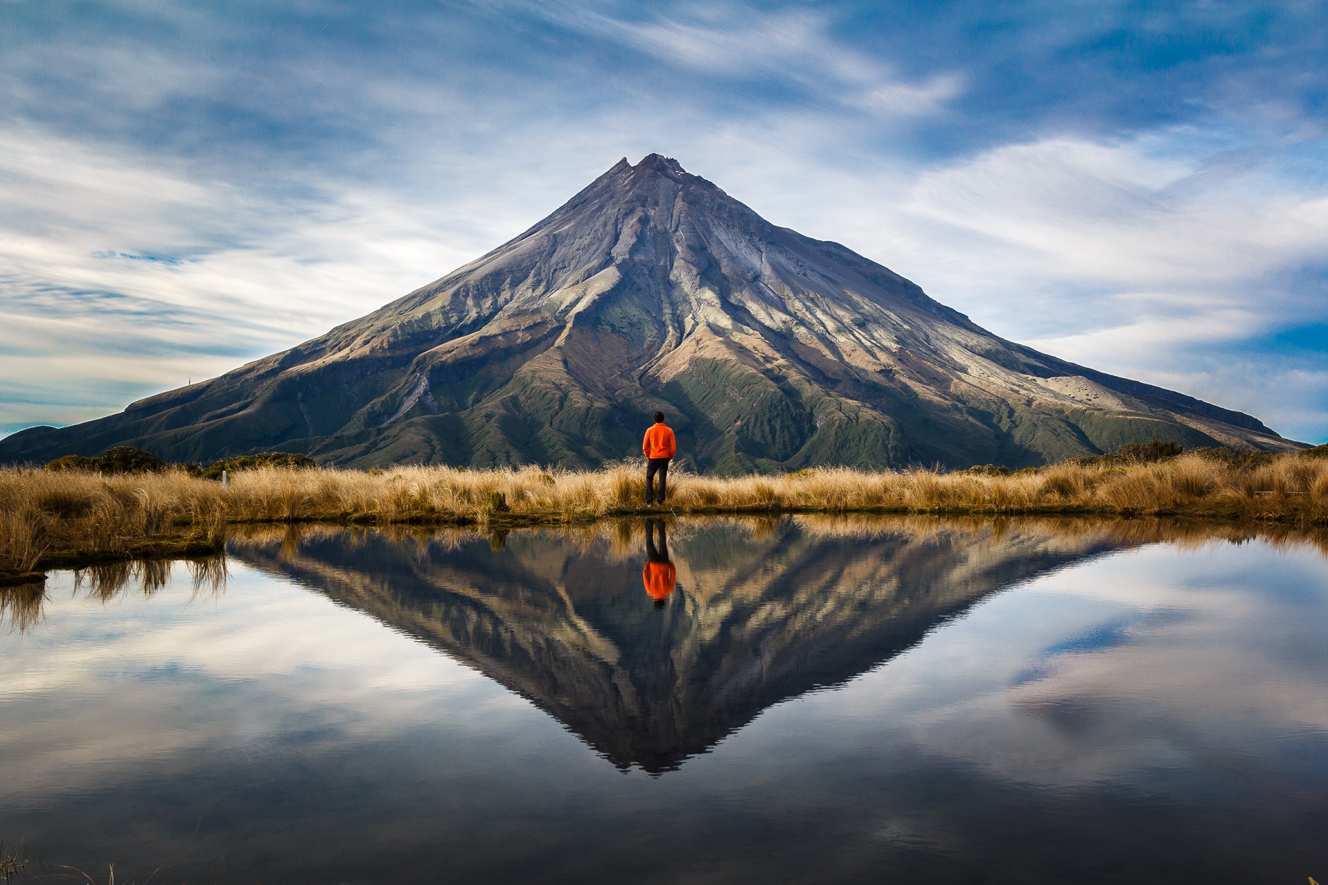 A,mountaineer,with,an,orange,dress,in,a,symmetric,picture