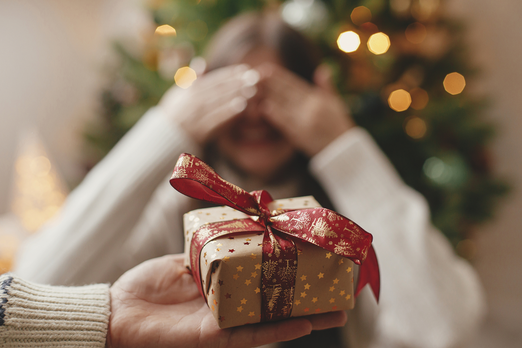 Merry,christmas,and,happy,holidays!,hand,holding,christmas,gift,box