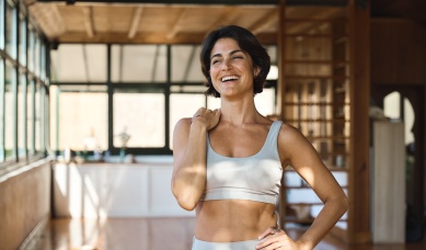 Happy,young,latin,woman,yoga,coach,laughing,standing,in,yoga